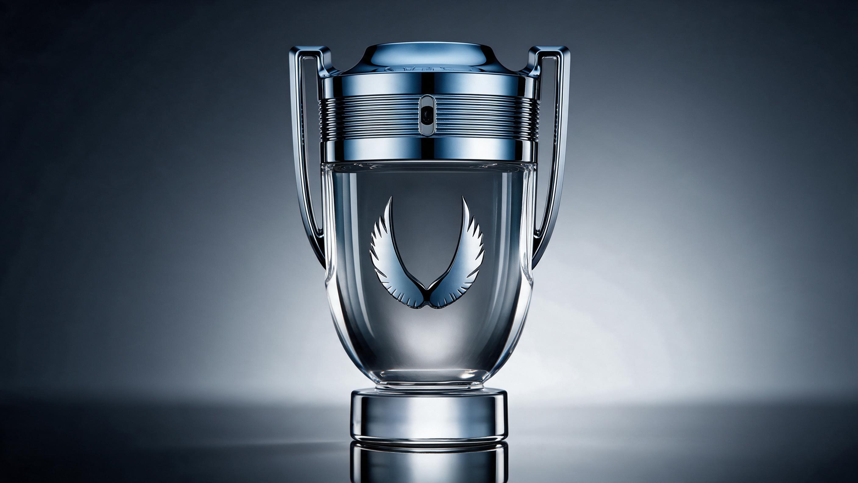 professional studio product photograph of a men's cologne bottle with a metallic silver-blue cap and angular facete