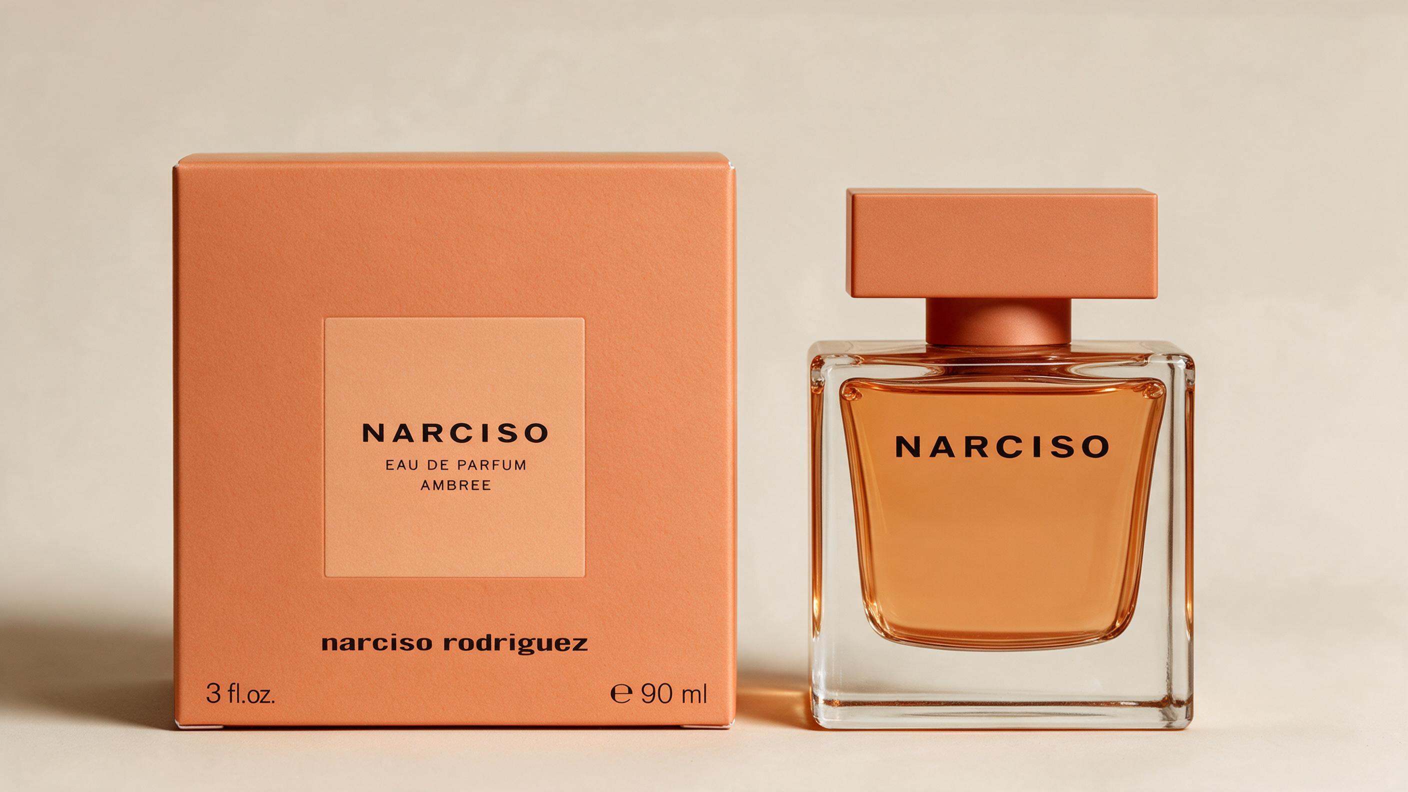 Elegant perfume bottle of a warm amber-toned women's eau de parfum, minimalist rectangular glass design, soft studi