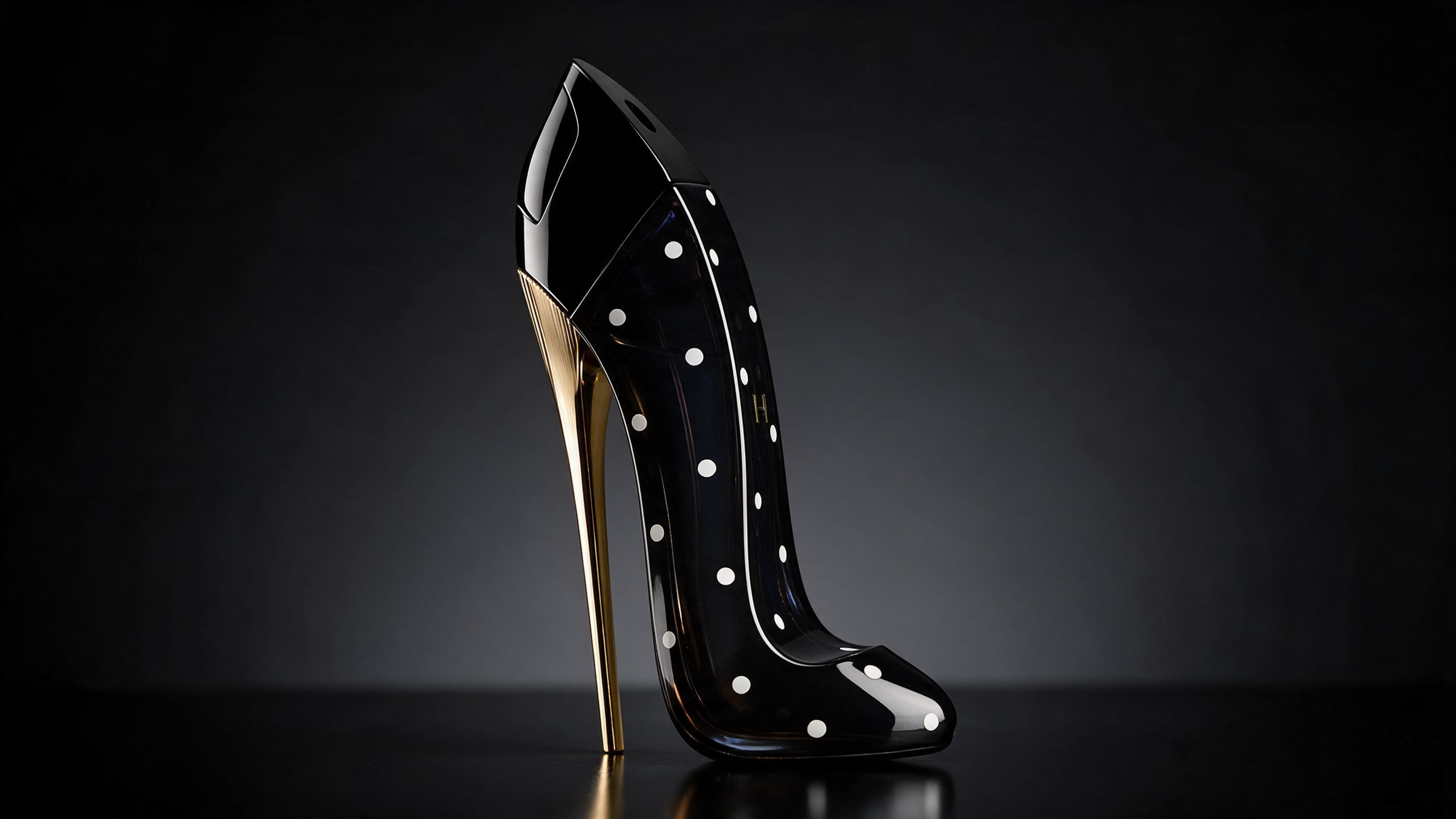 product photograph of a high-heel shoe-shaped perfume bottle with a bold black and white polka dot pattern on its surfac