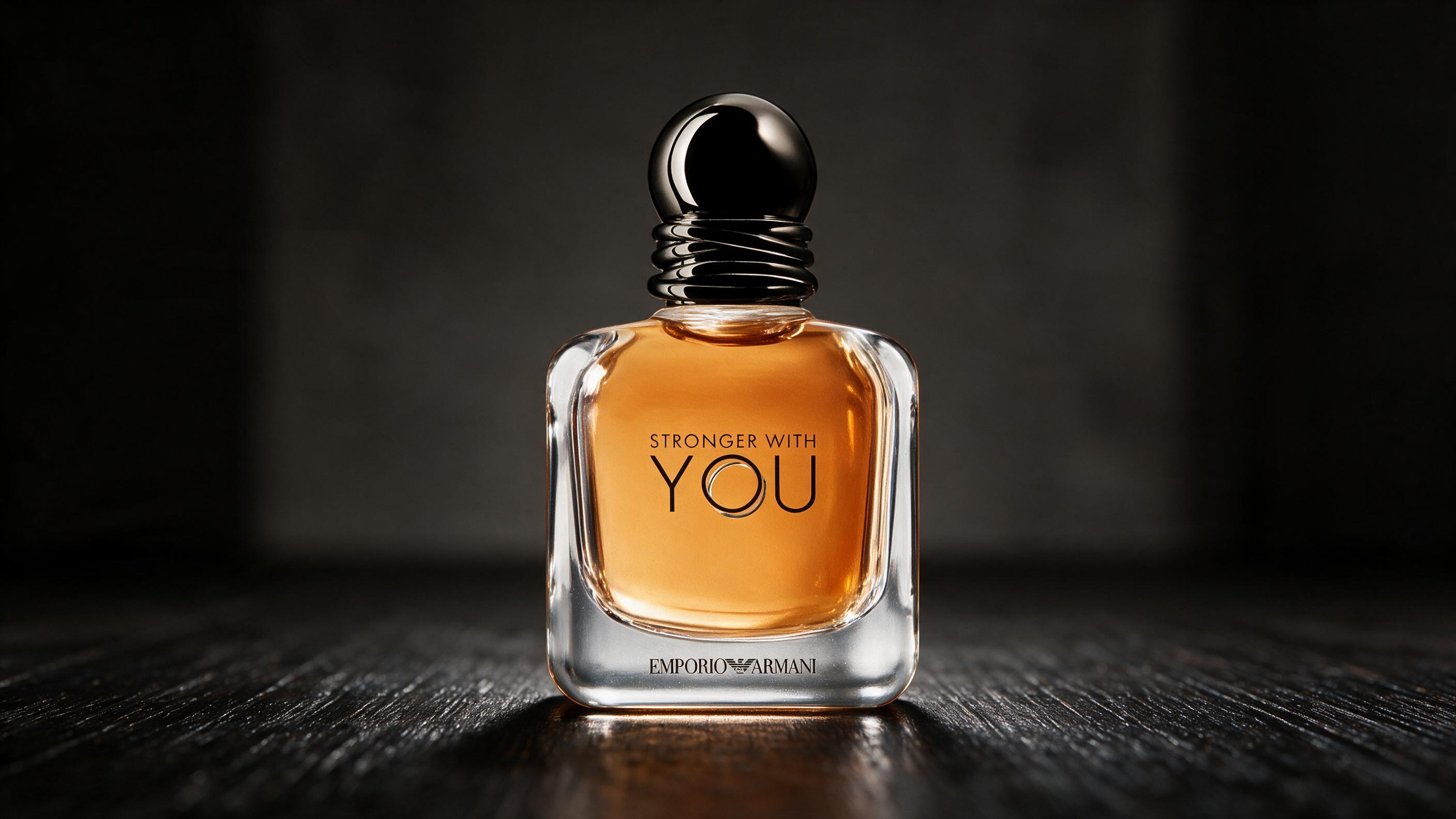 Emporio Armani Stronger With You perfume bottle, dark thick glass with black cap, standing on a dark wooden surface, dra