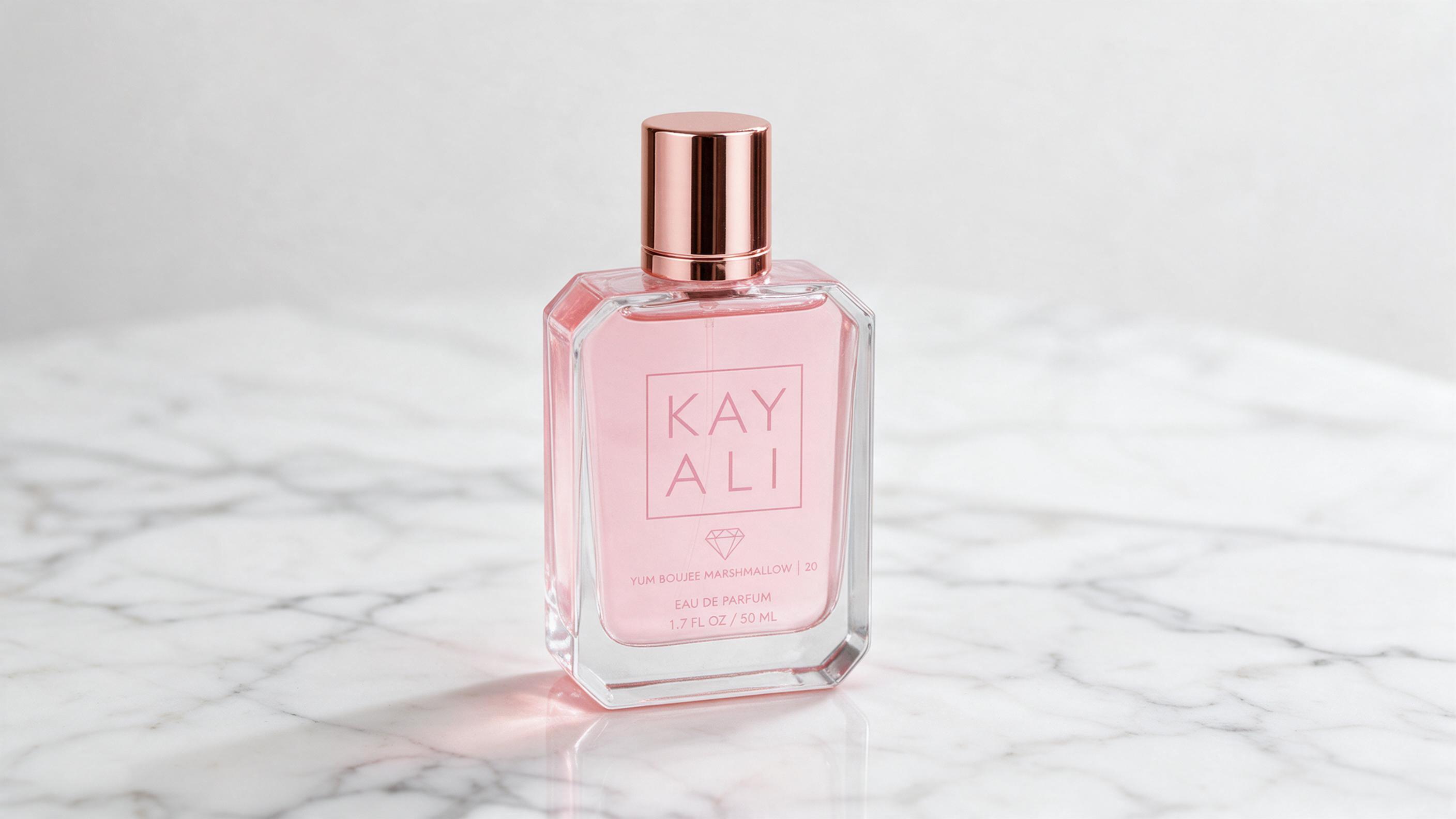 elegant pink perfume bottle labeled Yum Boujee Marshmallow style, pastel pink liquid, studio product photography on whit